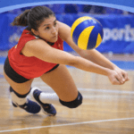 Female volleyball player diving for a ball on-court
